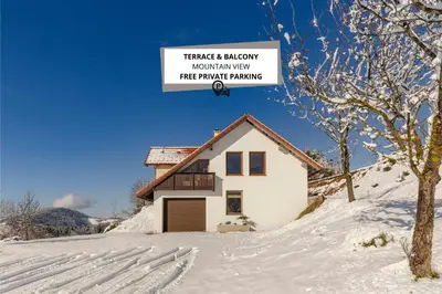 a house on a snowy hill with a sign that reads therapist alwaysmaximum anniversary free at Guest House Štruc in Slovenj Gradec