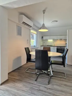a dining room and kitchen with a table and chairs at Apartment PETRA Mojstrana in Mojstrana