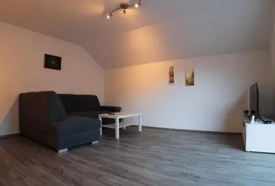 a living room with a couch and a tv at Apartment PETRA Mojstrana in Mojstrana