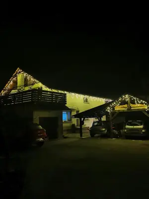 a house with lights on the roof at night at Apartment PETRA Mojstrana in Mojstrana