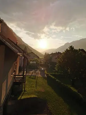 a view of a house with the sunset in the background at Apartment PETRA Mojstrana in Mojstrana