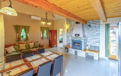 a living room with a table and a fireplace at Stunning Home In Velika Nedelja in Velika Nedelja