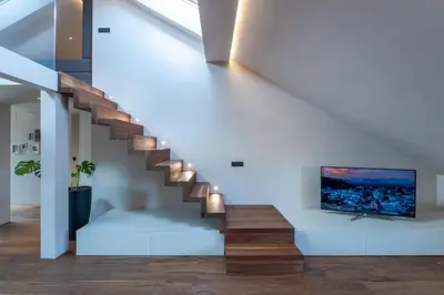 a living room with a staircase with a flat screen tv at Authentic City Stay in Ljubljana