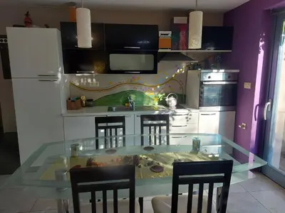 a kitchen with a glass table and some chairs at Guest House Bitter in Braslovče