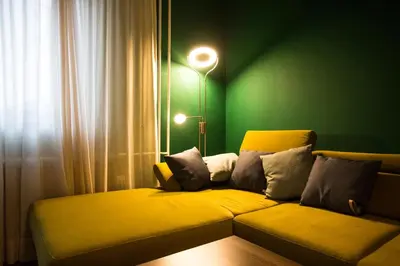 a couch in a room with a green wall at Cozy apartment in heart of Maribor / big terrace in Maribor