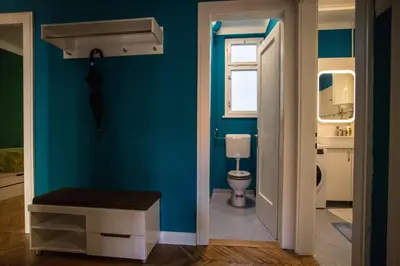 a bathroom with a toilet and a blue wall at Cozy apartment in heart of Maribor / big terrace in Maribor