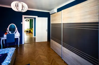 a bedroom with blue walls and a large wooden closet at Cozy apartment in heart of Maribor / big terrace in Maribor