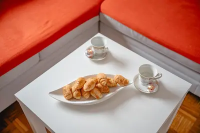 a table with a plate of cookies and two cups at Apartma Golob in Maribor