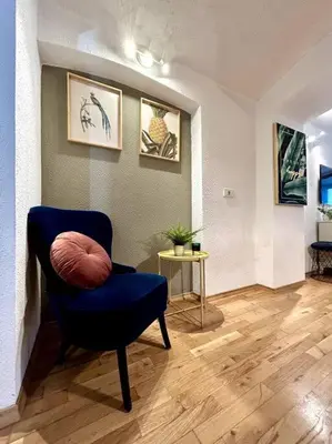a living room with a blue chair and a table at Charming appartment 3-min walk to old town - FREE PARKING in Ljubljana