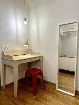 a desk with a red stool next to a mirror at Charming appartment 3-min walk to old town - FREE PARKING in Ljubljana