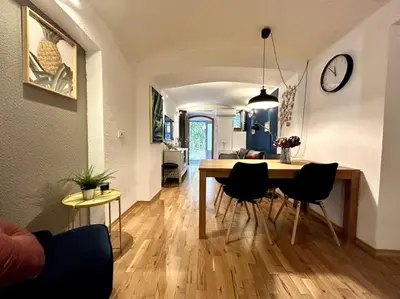 a dining room and living room with a table and chairs at Charming appartment 3-min walk to old town - FREE PARKING in Ljubljana
