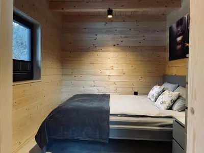 a bedroom with a bed in a wooden room at Radovna Chalet with Panoramic View in Mojstrana