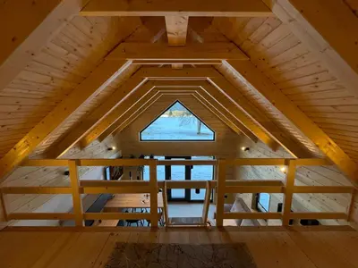 a loft in a tiny house with a window at Radovna Chalet with Panoramic View in Mojstrana