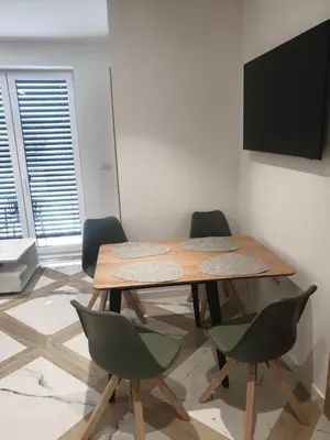 a table and chairs in a room with a television at PALAR Apartment in Ljubljana