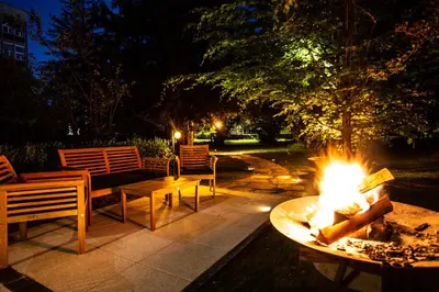 a fire pit in a yard with a table and chairs at Pipa’s Place - Stylish garden prime location apt in Ljubljana