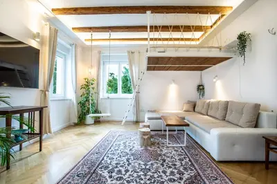 a living room with a white couch and a rug at Pipa’s Place - Stylish garden prime location apt in Ljubljana