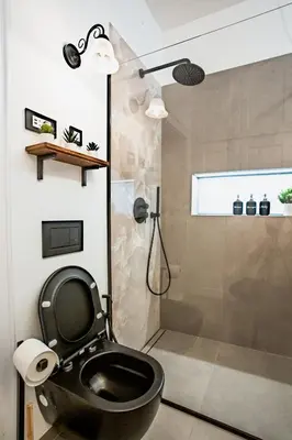 a bathroom with a black toilet and a shower at Pipa’s Place - Stylish garden prime location apt in Ljubljana