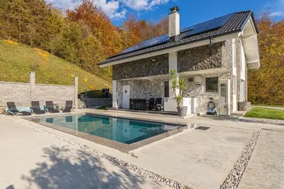 a home with a swimming pool in front of a house at Wellness Resort Trebnje in Trebnje