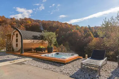 a hot tub and a chair in front of a cabin at Wellness Resort Trebnje in Trebnje