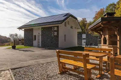a building with two wooden benches in front of it at Wellness Resort Trebnje in Trebnje
