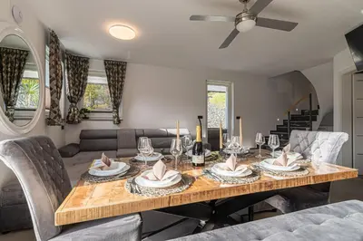 a dining room with a table with chairs and a couch at Wellness Resort Trebnje in Trebnje