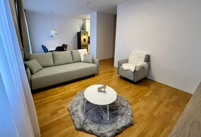 a living room with a couch and a table and a chair at SkiCity Apartment Pohorje Bellevue in Pohorje
