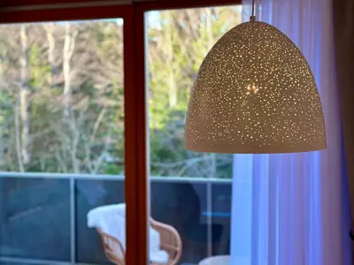 a lamp sitting in front of a window at SkiCity Apartment Pohorje Bellevue in Pohorje