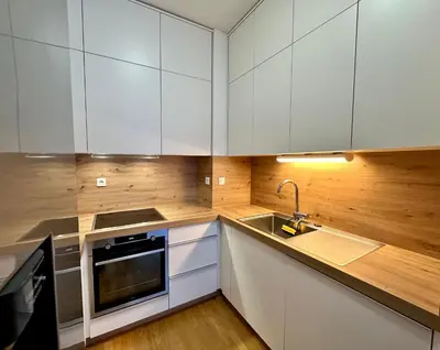 a kitchen with white cabinets and a sink at SkiCity Apartment Pohorje Bellevue in Pohorje