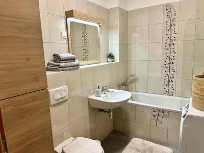 a bathroom with a sink and a toilet and a mirror at SkiCity Apartment Pohorje Bellevue in Pohorje