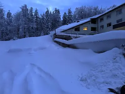 a pile of snow in front of a house at SkiCity Apartment Pohorje Bellevue in Pohorje