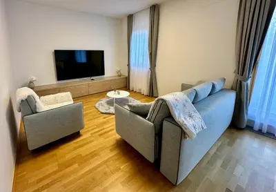 a living room with a couch and a tv at SkiCity Apartment Pohorje Bellevue in Pohorje