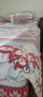 a blanket with snowmen on it on a bed at Idyllic Retreat Next to an Elven Forest in Gozd Martuljek