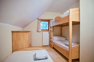 two bunk beds in a small room with a window at Apartma Smučišče Krvavec in Cerklje na Gorenjskem