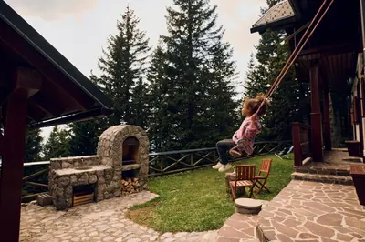 a little girl swinging on a porch swing at Apartma Smučišče Krvavec in Cerklje na Gorenjskem