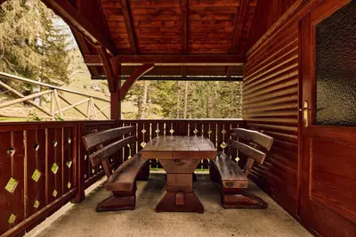 a wooden table and chairs on the porch of a cabin at Apartma Smučišče Krvavec in Cerklje na Gorenjskem