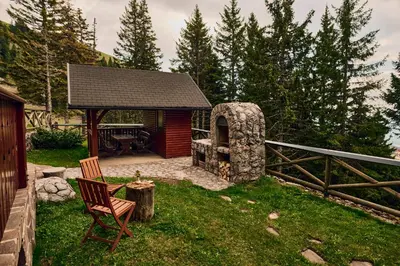 a gazebo with a table and a chair in a yard at Apartma Smučišče Krvavec in Cerklje na Gorenjskem