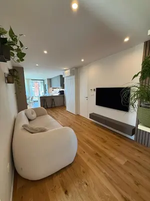 a living room with a white couch and a flat screen tv at Penthouse Apartment - Garden Residence in Ljubljana
