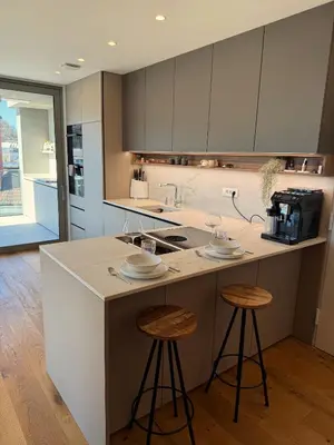 a kitchen with two bar stools and a counter top at Penthouse Apartment - Garden Residence in Ljubljana