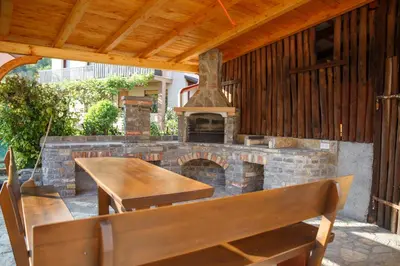 an outdoor patio with a brick fireplace and tables and chairs at Apartment Kolman in Tolmin