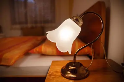 a lamp sitting on a table in front of a bed at Apartment Kolman in Tolmin