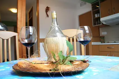 a bottle of wine sitting on a table with two wine glasses at Apartment Kolman in Tolmin