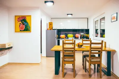 a kitchen with a table and chairs and a refrigerator at Apartment House VINARIA in Zgornja Ložnica