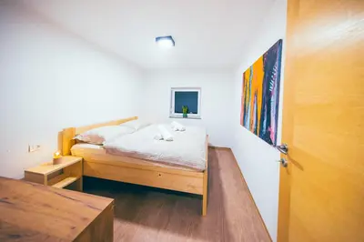 a small bedroom with a bed and a door at Apartment House VINARIA in Zgornja Ložnica