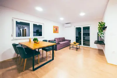 a living room with a table and a couch at Apartment House VINARIA in Zgornja Ložnica