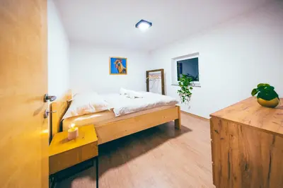 a bedroom with a bed and a table in it at Apartment House VINARIA in Zgornja Ložnica