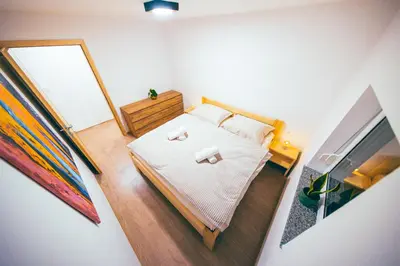 a small bedroom with a bed and a mirror at Apartment House VINARIA in Zgornja Ložnica