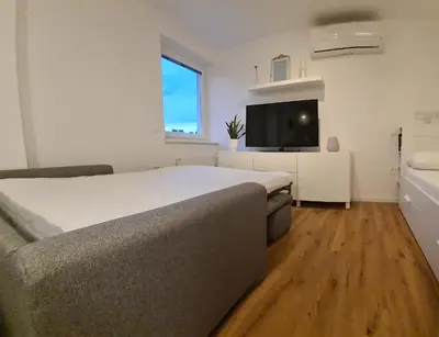 a bedroom with a bed and a flat screen tv at Little Plaza City Centre in Ljubljana