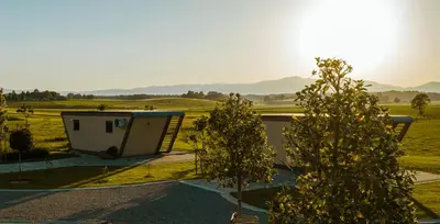 a view of a building and trees in a field at Fortun Estate - apartmaji ob reki Kolpi in Metlika