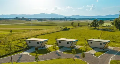 an aerial view of three buildings in a field at Fortun Estate - apartmaji ob reki Kolpi in Metlika