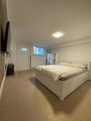 a bedroom with a bed and a flat screen tv at Laibach Suite in Ljubljana